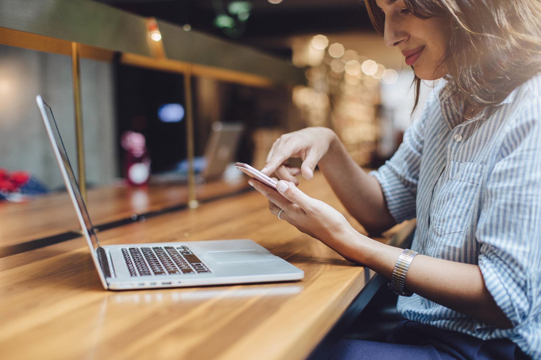 woman on phone working on a laptop